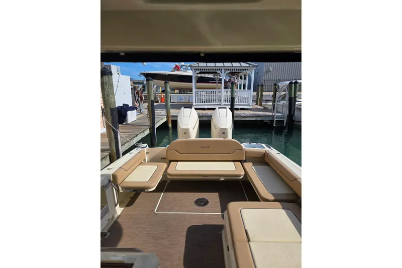 Slide: The Image of 2023 Chris-Craft Calypso 35 boat interior with tan seating at a marina dock. - 8