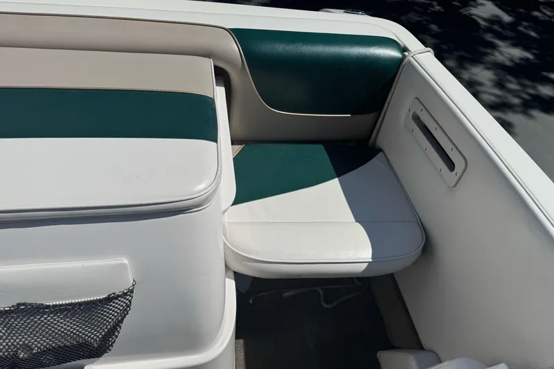 Slide: The Image of Interior seating of a 2001 Reinell 203 boat, featuring green and white upholstery. - 15