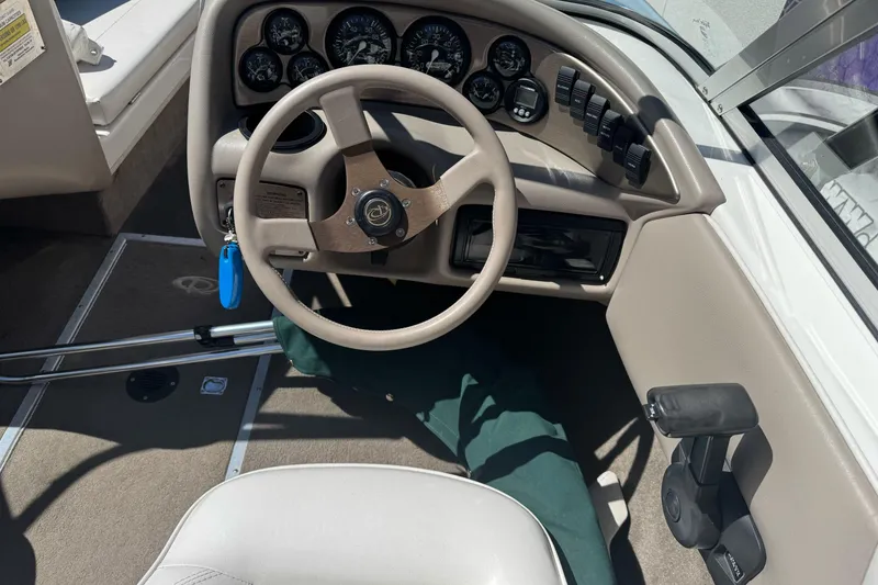 Slide: The Image of Steering wheel and dashboard of a 2001 Reinell 203 boat, featuring gauges and controls. - 18