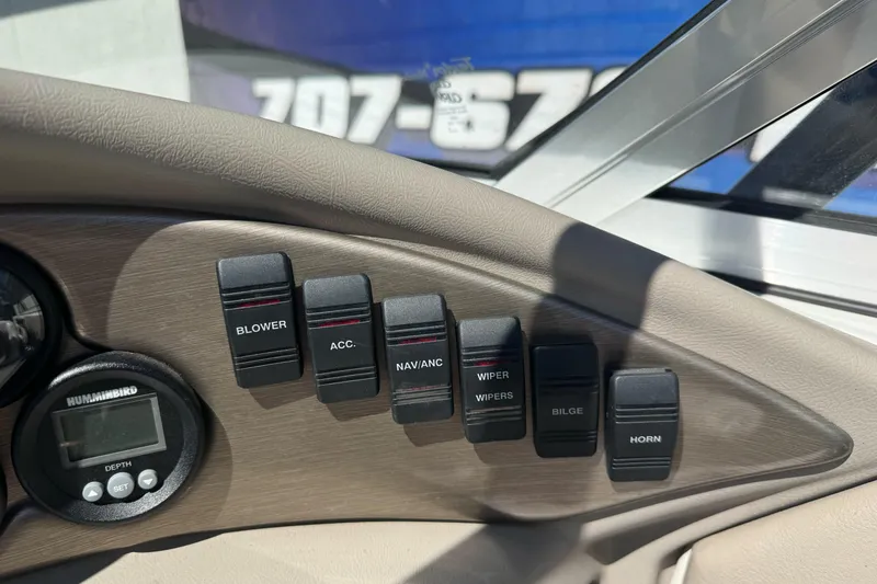 Slide: The Image of Control panel of a 2001 Reinell 203 boat with labeled switches and depth gauge. - 20