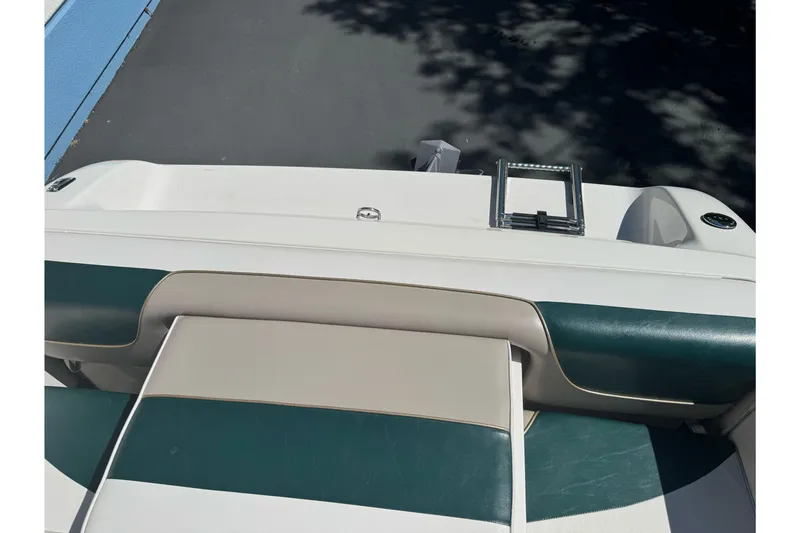 Slide: The Image of 2001 Reinell 203 boat interior with green and beige seating, ladder visible. - 24