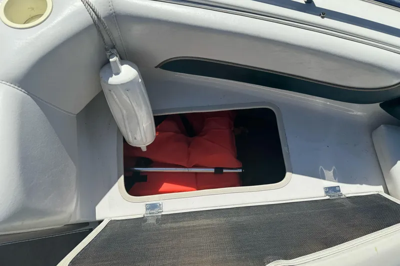 Slide: The Image of Storage compartment in a 2001 Reinell 203 boat with life jackets and fender. - 8