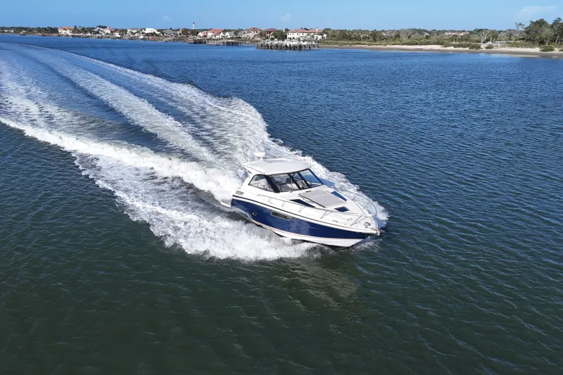 Slide: The Image of 2016 Regal 35 Sport Coupe cruising on open water, leaving a wake behind. - 12