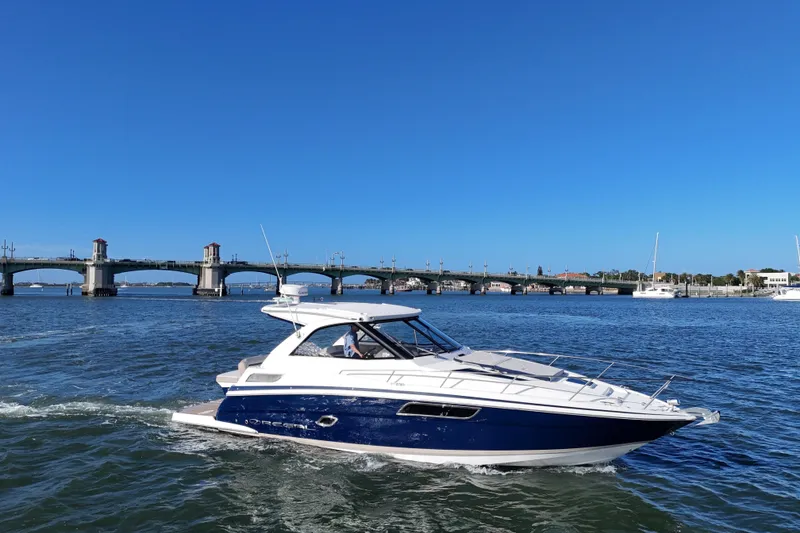 Slide: The Image of 2016 Regal 35 Sport Coupe cruising near a scenic bridge on a sunny day. - 16