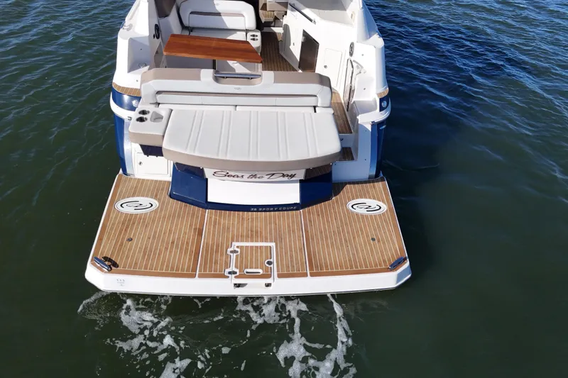 Slide: The Image of 2016 Regal 35 Sport Coupe boat with teak deck and seating, on water. - 19