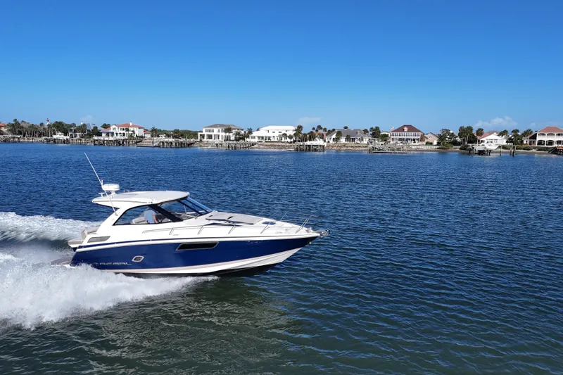 Slide: The Image of 2016 Regal 35 Sport Coupe cruising on a sunny day near waterfront homes. - 3