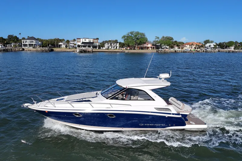 Slide: The Image of 2016 Regal 35 Sport Coupe cruising on a sunny day near waterfront homes. - 4