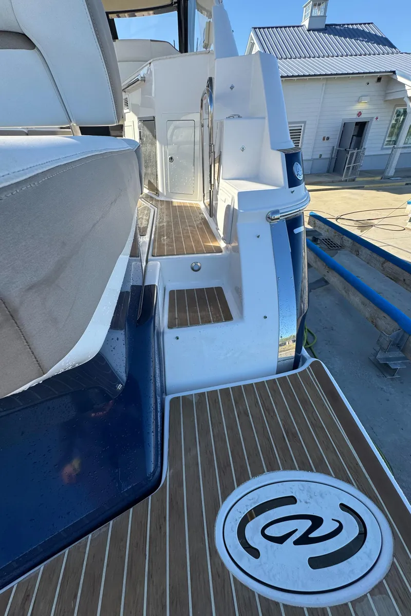 Slide: The Image of 2016 Regal 35 Sport Coupe boat deck with wood finish and seating area. - 56