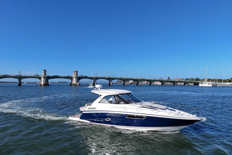 Slide: The Image of 2016 Regal 35 Sport Coupe cruising near a scenic bridge on a sunny day. - 62