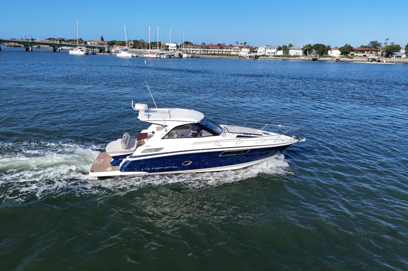 Slide: The Image of 2016 Regal 35 Sport Coupe cruising on a sunny day near a coastal town. - 64