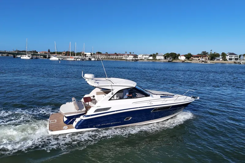 Slide: The Image of 2016 Regal 35 Sport Coupe cruising on a sunny day near a coastal town. - 65
