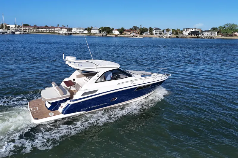 Slide: The Image of 2016 Regal 35 Sport Coupe cruising on a scenic waterway with coastal homes in the background. - 66