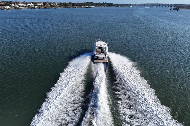 Slide: The Image of 2016 Regal 35 Sport Coupe cruising on open water, leaving a wake trail. - 68