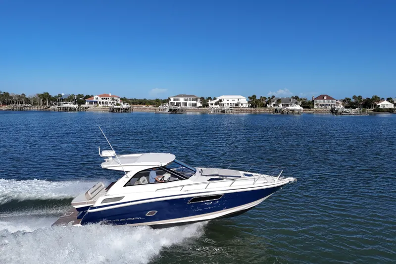 Slide: The Image of 2016 Regal 35 Sport Coupe cruising on a sunny day near waterfront homes. - 70