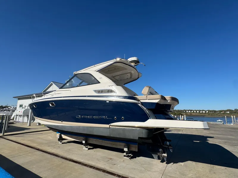 Slide: The Image of 2016 Regal 35 Sport Coupe boat on dry dock under clear blue sky. - 93