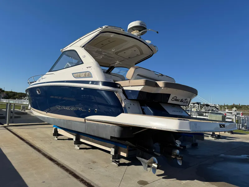 Slide: The Image of 2016 Regal 35 Sport Coupe boat on a dock under clear blue sky. - 94