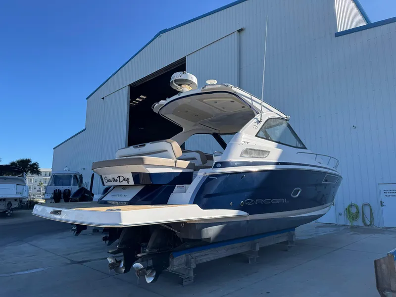 Slide: The Image of 2016 Regal 35 Sport Coupe boat docked near a large warehouse. - 99