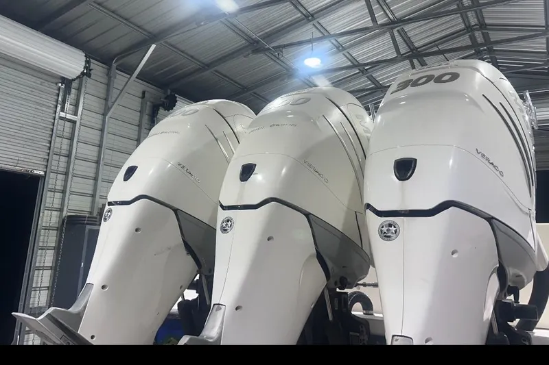 Slide: The Image of Three powerful outboard motors on a 2005 Contender 35 ST boat in a garage. - 10