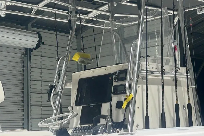 Slide: The Image of 2005 Contender 35 ST boat console with fishing rods and steering wheel in a garage. - 5