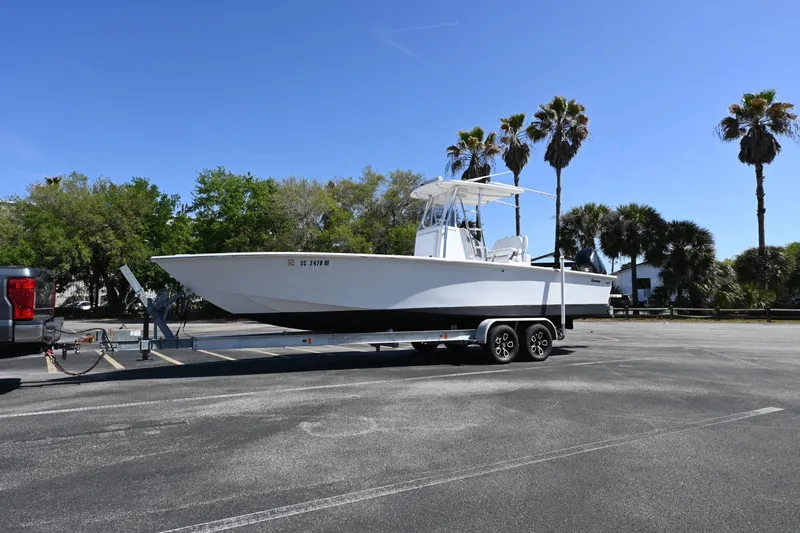 Slide: The Image of Trailered 2017 Rambo 27 boat in parking lot with palm trees and clear sky. - 15