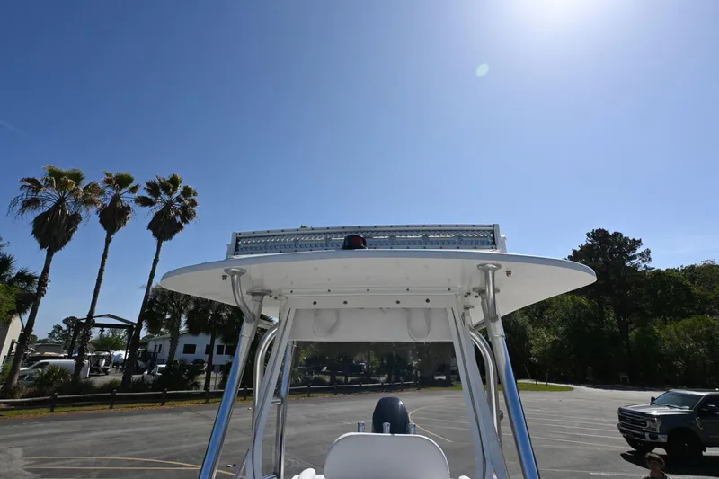 Slide: The Image of 2017 Rambo 27 boat with T-top, parked under clear blue sky, surrounded by palm trees. - 5