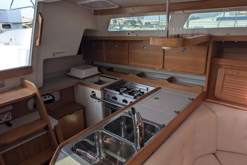 Slide: The Image of Interior of 2007 Catalina 36 MkII sailboat featuring a compact kitchen and seating area. - 25