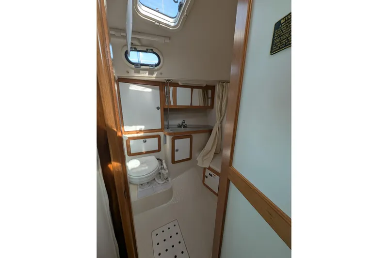 Slide: The Image of Interior of 2007 Catalina 36 MkII sailboat bathroom with toilet, sink, and storage cabinets. - 28