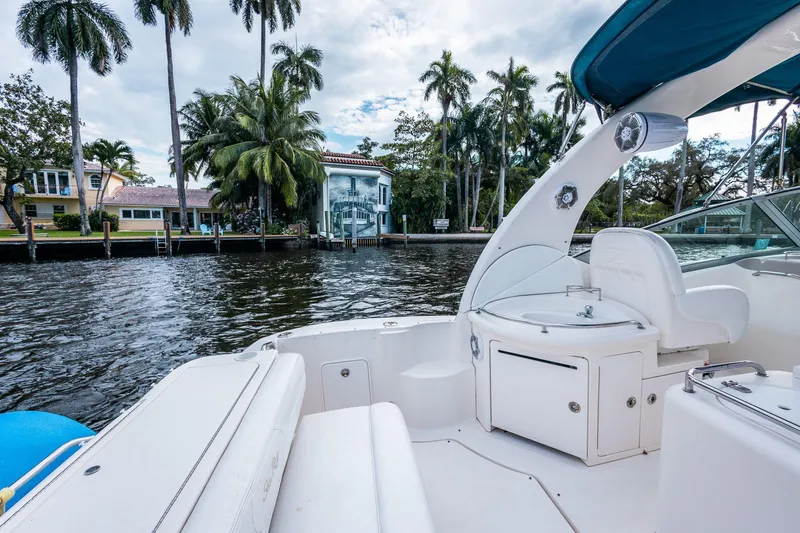 Slide: The Image of 2005 Sea Ray 340 Sundancer yacht on a scenic waterfront with palm trees and luxury homes. - 14