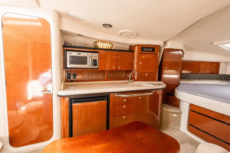 Slide: The Image of 2005 Sea Ray 340 Sundancer interior with kitchenette, microwave, and cozy sleeping area. - 18