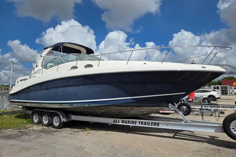 Slide: The Image of 2005 Sea Ray 340 Sundancer boat on trailer under a blue sky with clouds. - 21