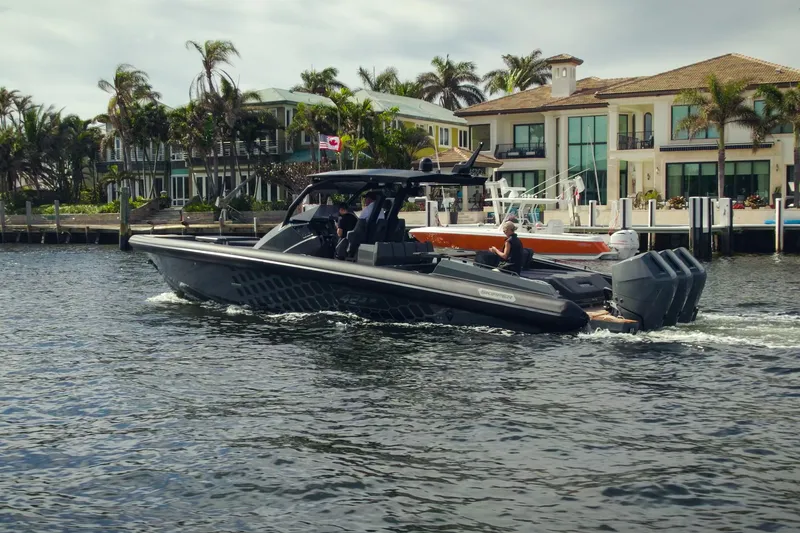 Slide: The Image of 2024 Skipper-BSK 42 boat cruising on water with city skyline in the background. - 5