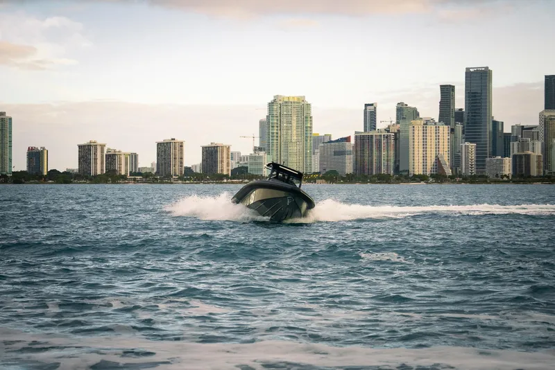 Slide: The Image of Skipper-BSK 42 boat cruising near city skyline, 2024 model. - 8