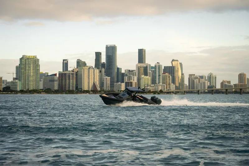 Slide: The Image of Skipper-BSK 42 boat cruising near a city skyline, 2024 model. - 9