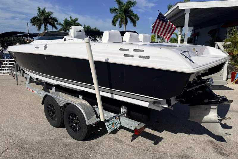 Slide: The Image of 2007 Donzi 27 ZR speedboat with sleek white design, parked at a marina under blue skies. - 12