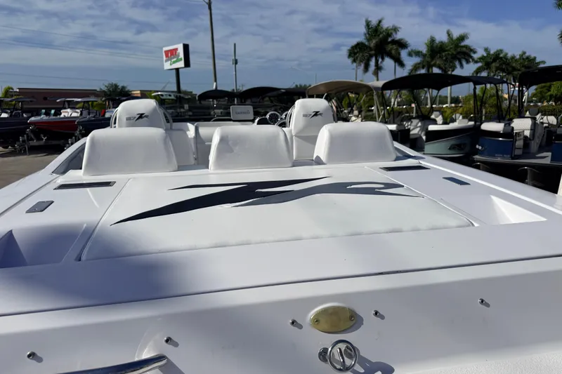 Slide: The Image of 2007 Donzi 27 ZR speedboat with sleek white design, docked among other boats. - 13