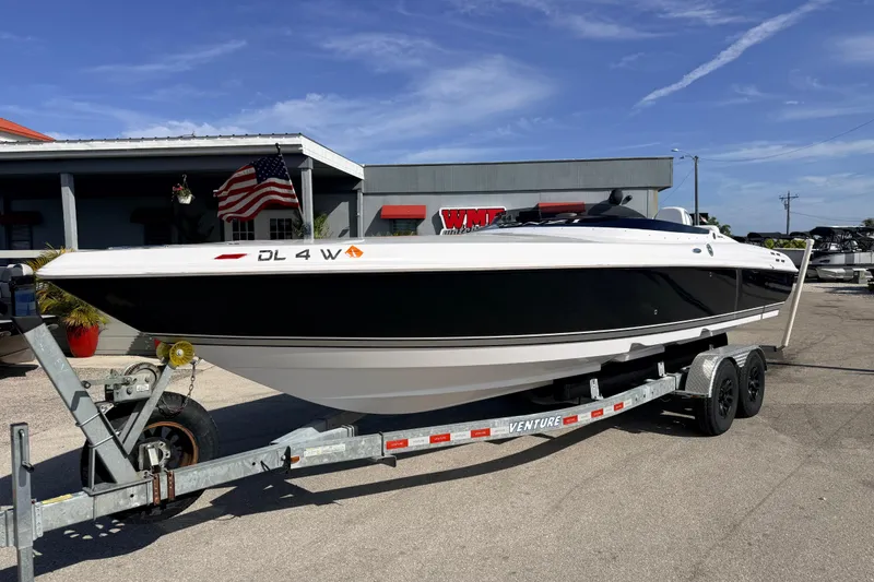Slide: The Image of 2007 Donzi 27 ZR speedboat on trailer, parked outside dealership with American flag. - 2