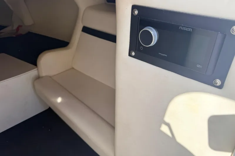 Slide: The Image of Interior of a 2007 Donzi 27 ZR boat, featuring beige seating and carpeted flooring. - 31