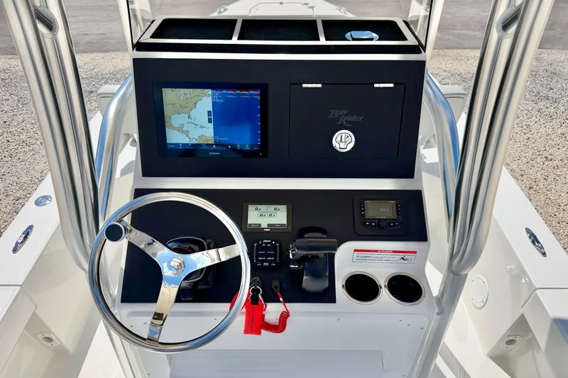 Slide: The Image of 2026 Bay Rider 219 Bay boat dashboard with steering wheel, navigation screen, and controls. - 15
