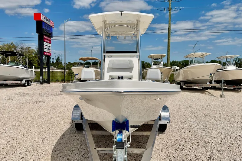 Slide: The Image of 2026 Bay Rider 219 Bay boat on trailer at dealership under blue sky. - 2