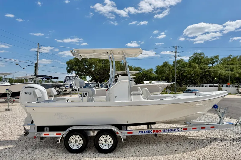 Slide: The Image of 2026 Bay Rider 219 Bay boat on trailer under clear blue sky. - 4