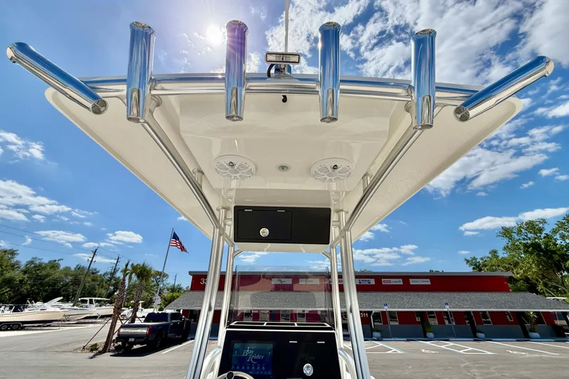 Slide: The Image of 2026 Bay Rider 219 Bay boat with T-top and rod holders under sunny sky. - 47