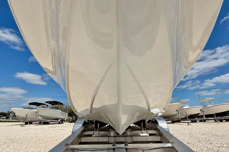 Slide: The Image of 2026 Bay Rider 219 Bay boat hull on trailer under clear blue sky. - 49
