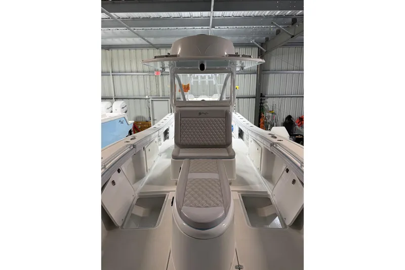 Slide: The Image of 2021 Yellowfin 36 Offshore boat interior with cushioned seating in a storage facility. - 28