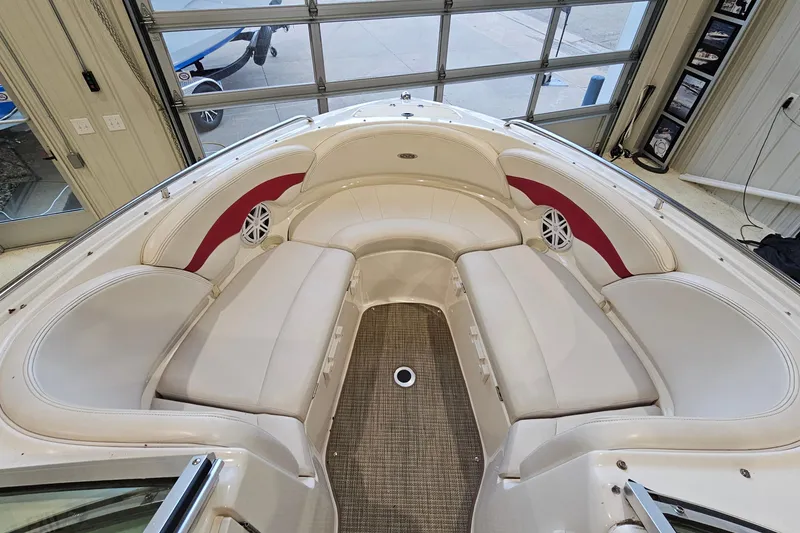 Slide: The Image of 2000 Chaparral 230 SSi boat interior with white and red seating in a garage. - 14