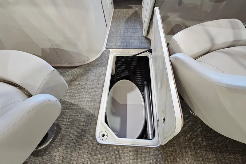 Slide: The Image of Storage compartment in 2000 Chaparral 230 SSi boat, featuring beige seating and carpeted flooring. - 21