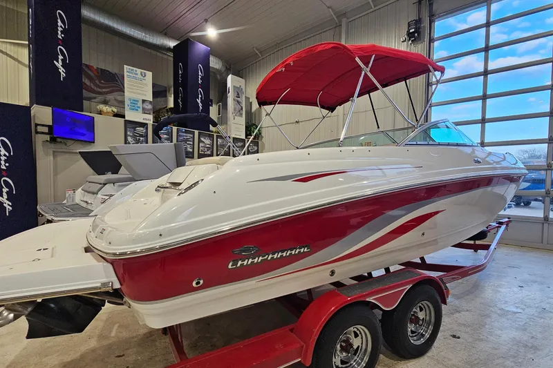 Slide: The Image of 2000 Chaparral 230 SSi boat with red accents and canopy in showroom. - 3