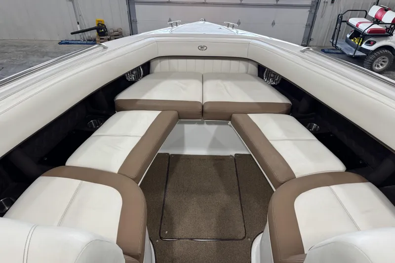 Slide: The Image of 2015 Cobalt 302 boat interior with white and brown seating in a garage setting. - 19