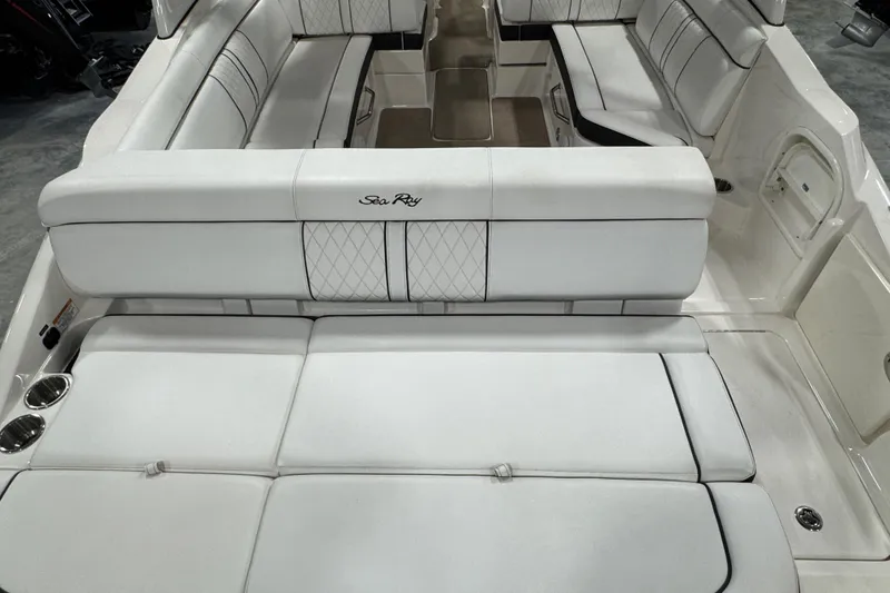 Slide: The Image of 2015 Sea Ray SDX 270 boat interior with white cushioned seating and cup holders. - 12
