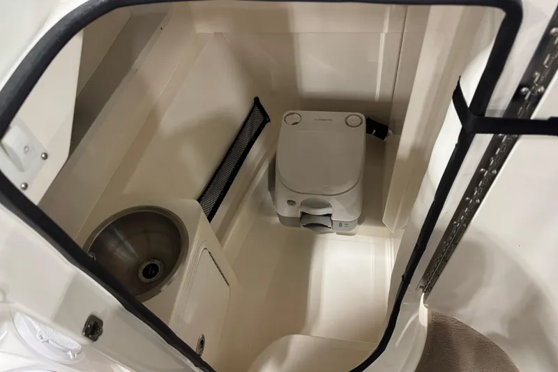 Slide: The Image of 2015 Sea Ray SDX 270 boat interior with compact toilet and sink. - 14