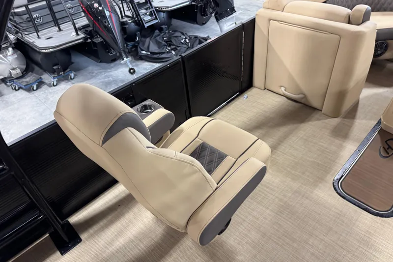 Slide: The Image of 2022 Harris Sunliner 230 boat interior with beige seating and cup holder. - 13
